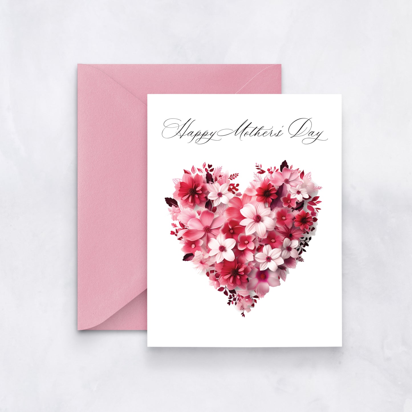 White greeting card with a pink and red heart made of flowers and cursive “Happy Mother’s Day” text, styled with a pink envelope.
