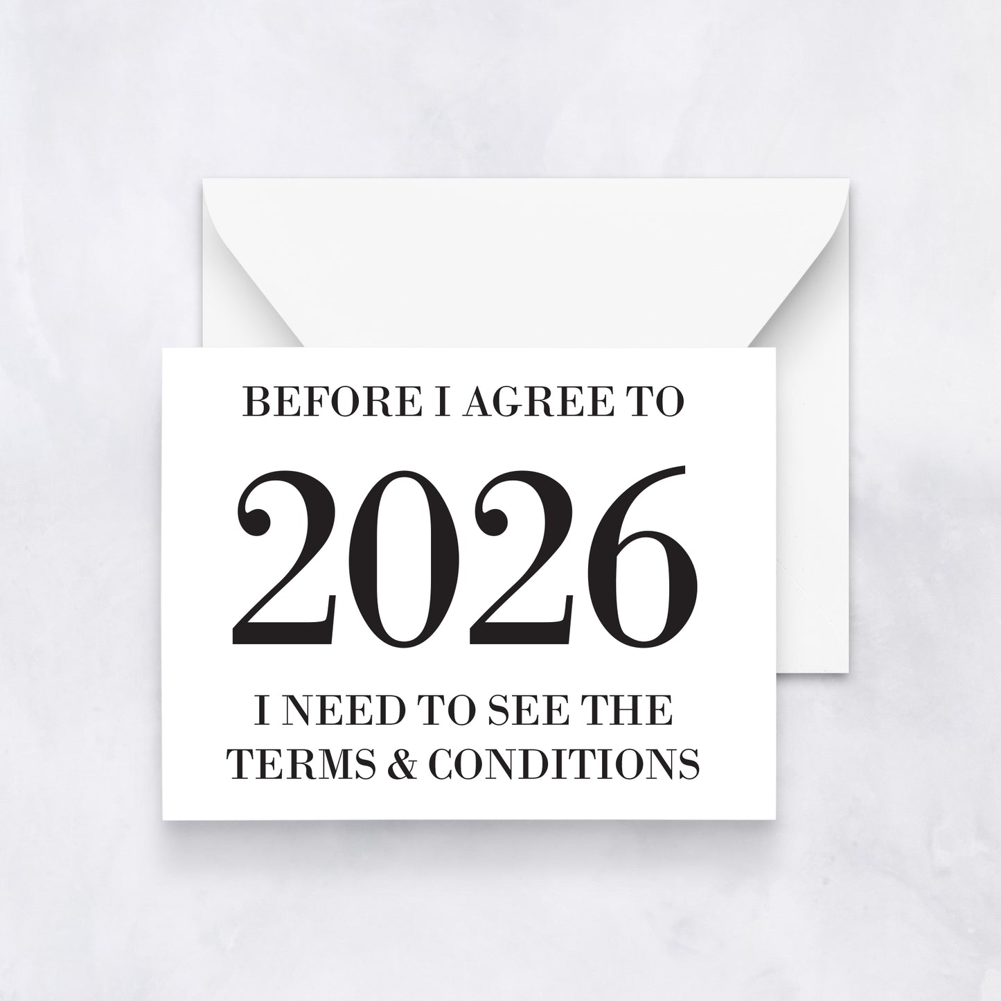 White greeting card with bold black text reading “Before I agree to 2026 I need to see the terms & conditions,” styled with a white envelope.