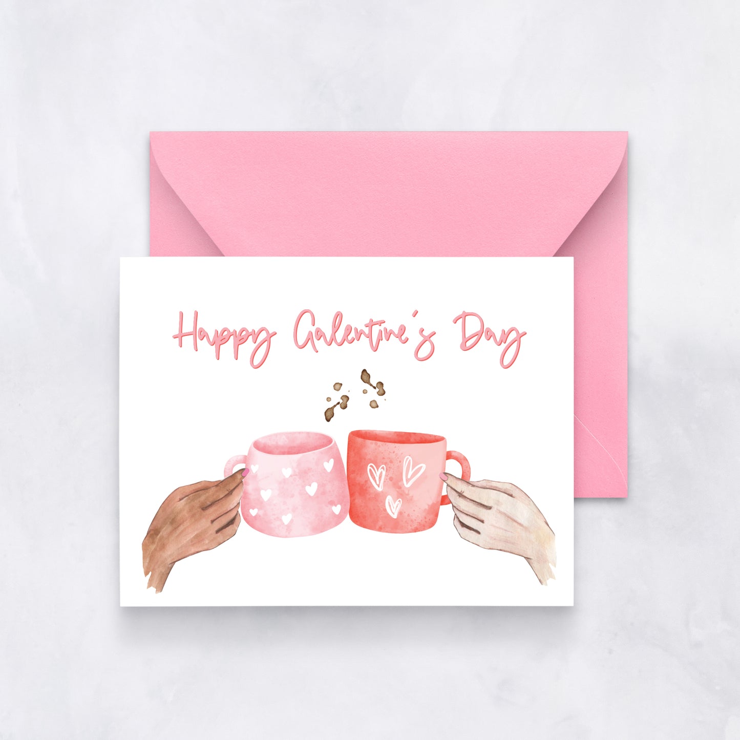 White card with two watercolor mugs and text “Happy Galentine’s Day,” paired with a pink envelope.