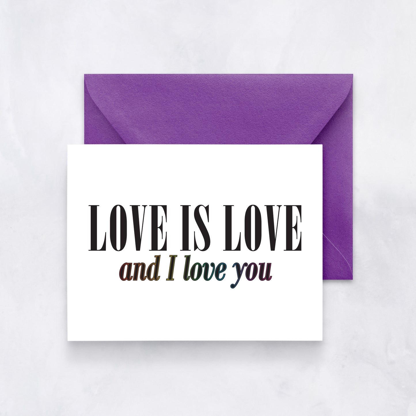 White card with bold black and rainbow text reading “Love is love and I love you,” styled with a purple envelope.