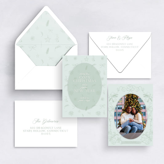 Mint green Cozy Christmas card with illustrated frame and couple’s holiday photo.