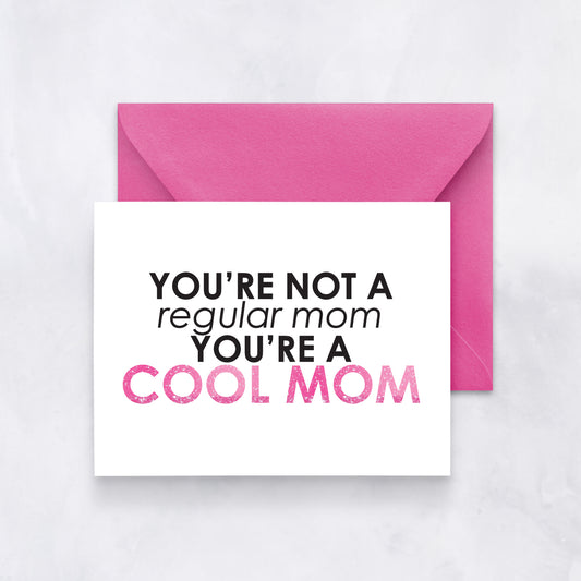Greeting card with bold black and pink text reading “You’re not a regular mom, you’re a cool mom,” styled with a hot pink envelope.