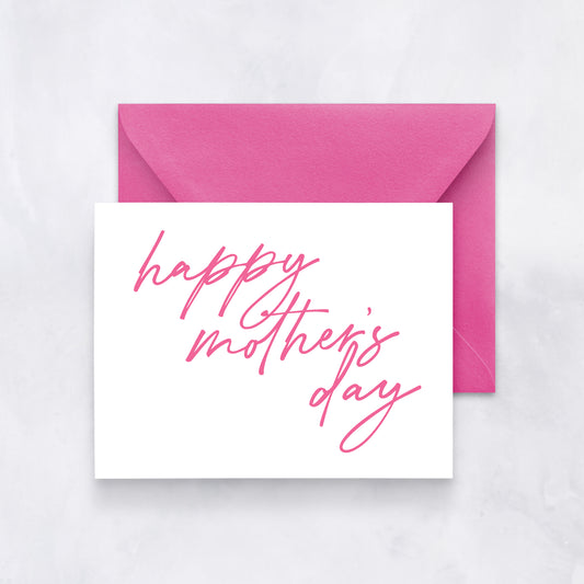 White greeting card with large pink script reading “happy mother’s day,” styled with a bright pink envelope.