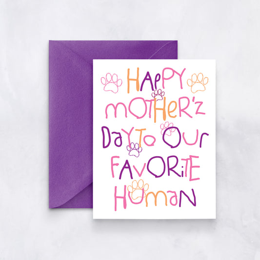 White greeting card with pink, orange, and purple lettering that reads “Happy Mother’z Day to our favorite human,” with paw prints and a purple envelope.