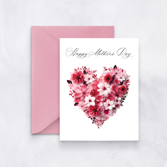 White greeting card with a pink and red heart made of flowers and cursive “Happy Mother’s Day” text, styled with a pink envelope.