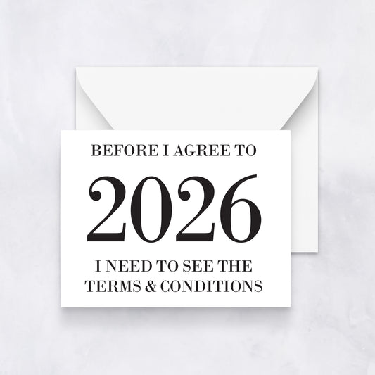 White greeting card with bold black text reading “Before I agree to 2026 I need to see the terms & conditions,” styled with a white envelope.