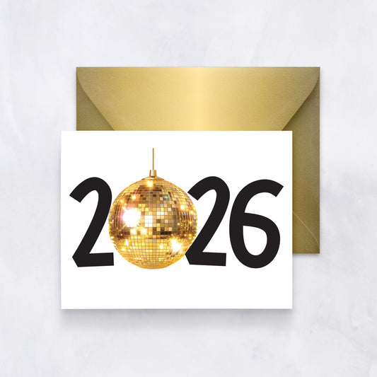White greeting card with “2026” where the zero is replaced by a golden disco ball, styled with a gold envelope.
