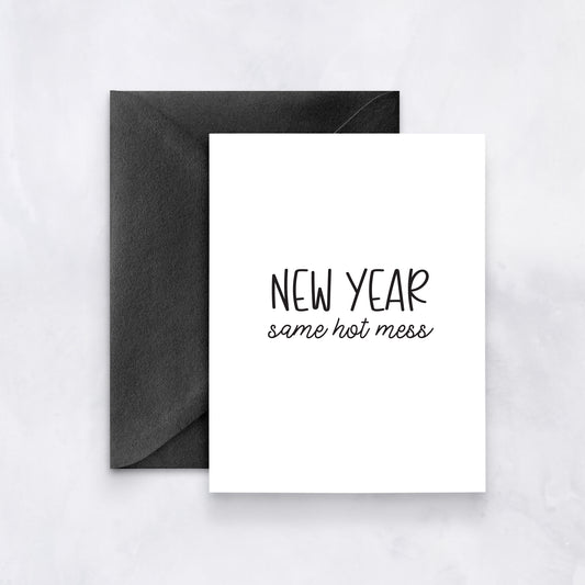 White greeting card with black text reading “New Year same hot mess,” paired with a black envelope.