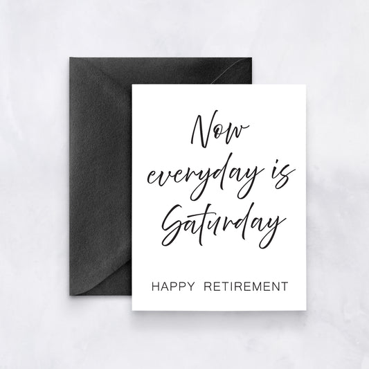 White greeting card with black handwritten script reading “Now everyday is Saturday – Happy Retirement,” paired with a black envelope.
