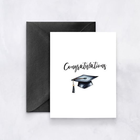 White card with “Congratulations” text and a watercolor graduation cap, paired with a black envelope.
