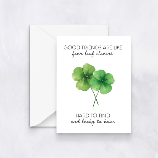 White card with two watercolor four-leaf clovers and text “Good friends are like four leaf clovers, hard to find and lucky to have,” paired with a white envelope.