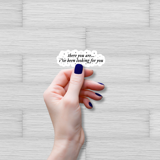 Hand holding a small card with text on a textured gray background