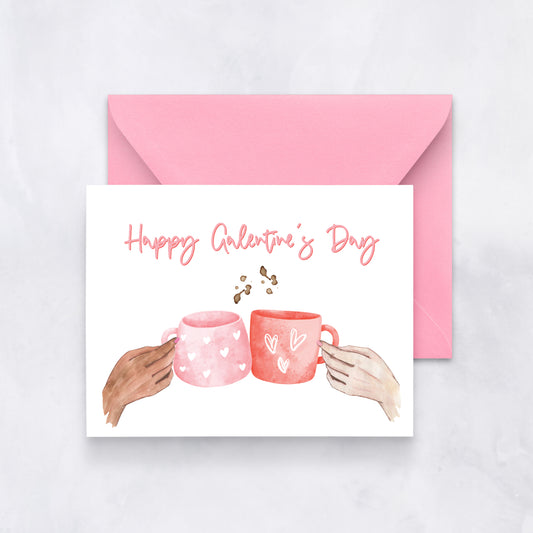 White card with two watercolor mugs and text “Happy Galentine’s Day,” paired with a pink envelope.