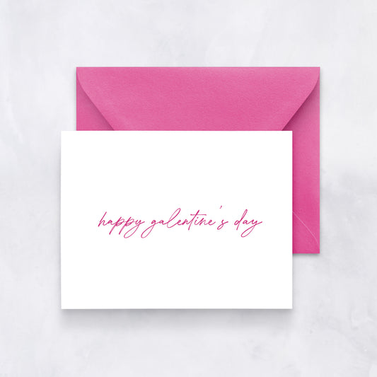 White card with handwritten pink script reading “happy galentine’s day,” paired with a pink envelope.