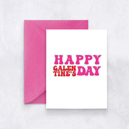 White card with pink and red retro text reading “Happy Galentine’s Day,” paired with a pink envelope.