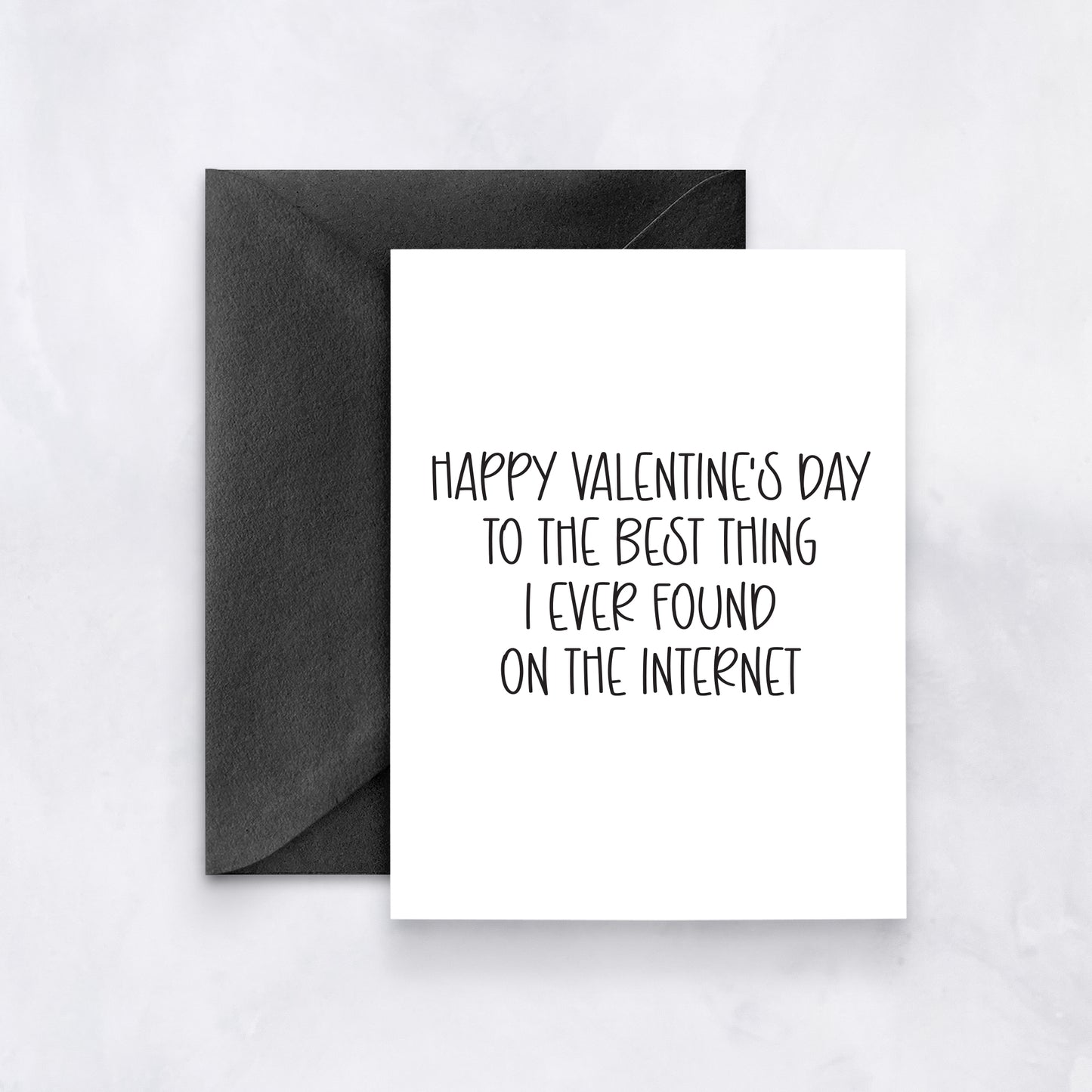 White card with black handwritten text reading “Happy Valentine’s Day to the best thing I ever found on the internet,” styled with a black envelope.