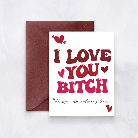 White card with red and pink retro text reading “I love you bitch – Happy Galentine’s Day,” styled with a maroon envelope.
